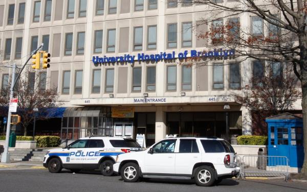 The main entrance to SUNY Downstate Medical Center in Brooklyn, with several cars parked at the doors.