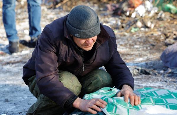 A man leans over the body of his wife who was killed in the shelling at a food market in Donetsk, Ukraine on Sunday.