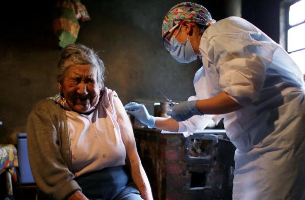 Ana Lucia Palacios (L) receives a dose of Sinovac Covid-19 vaccine in her house in Sumapaz, Bogota's rural zone on July 29, 2021.