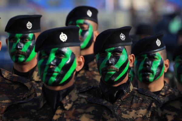 Members of the Iraqi security forces seen wearing black berets, and with green and black paint on their faces.